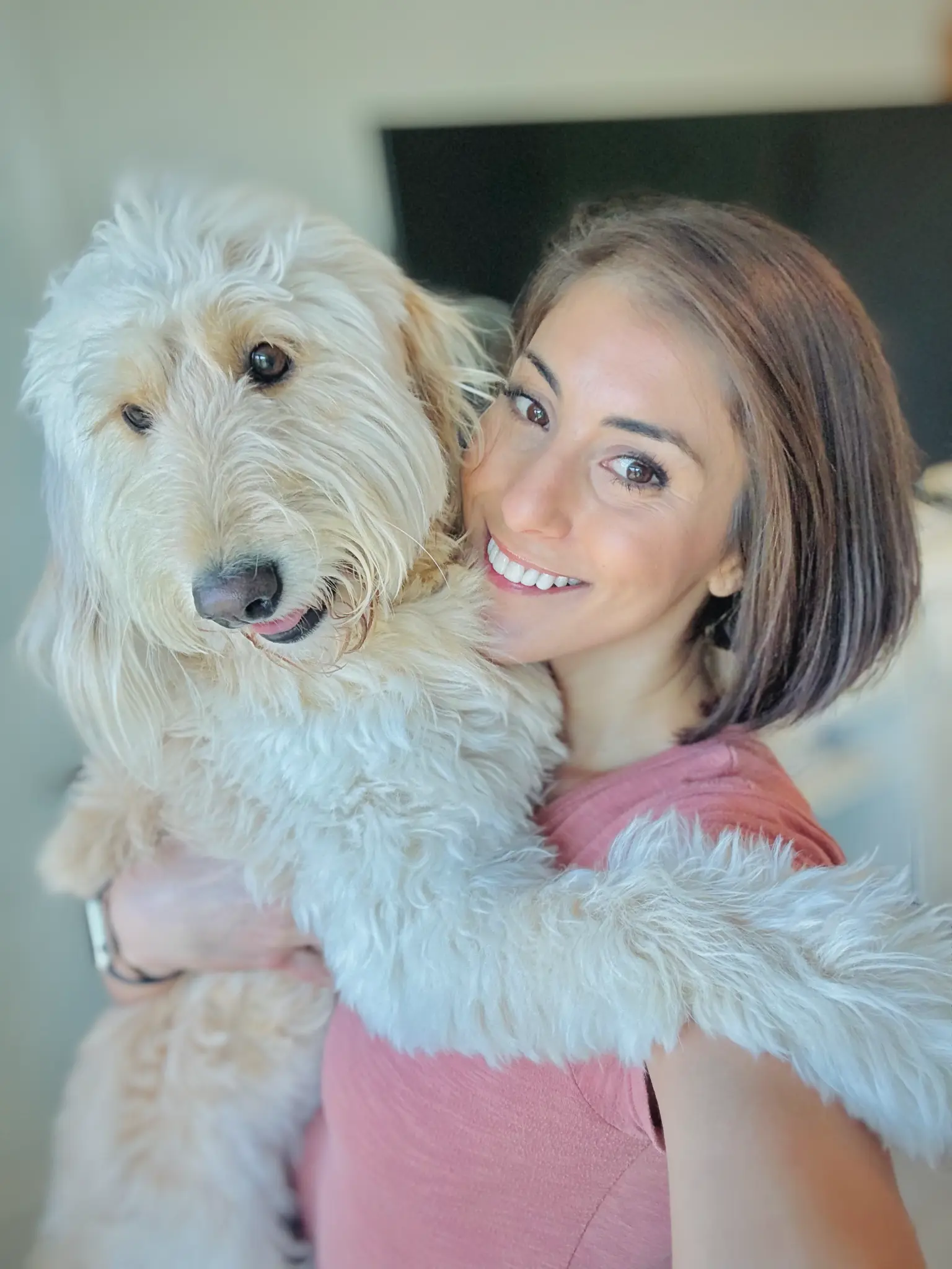 Caroline LaCamera, owner and Fear Free certified pet sitter at Ohh My Dog!, hugging a fluffy white doodle dog in Sarasota, FL
